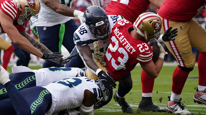 Nov 17, 2024; Santa Clara, California, USA; San Francisco 49ers running back Christian McCaffrey (23) is tackled by Seattle Seahawks linebacker Tyrice Knight (48) in the first quarter at Levi's Stadium. Mandatory Credit: David Gonzales-Imagn Images