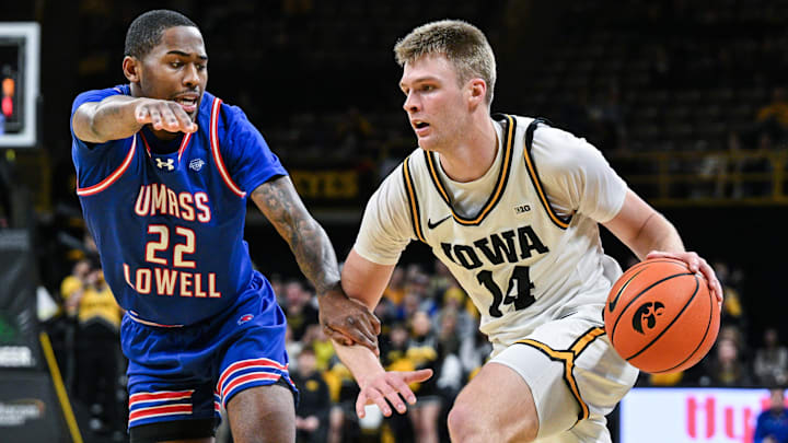 Dec 29, 2025; Iowa City, Iowa, USA; Iowa Hawkeyes guard Bennett Stirtz (14) controls the ball as UMass Lowell River Hawks guard Khalil Farmer (22) defends during the second half at Carver-Hawkeye Arena. Mandatory Credit: Jeffrey Becker-Imagn Images