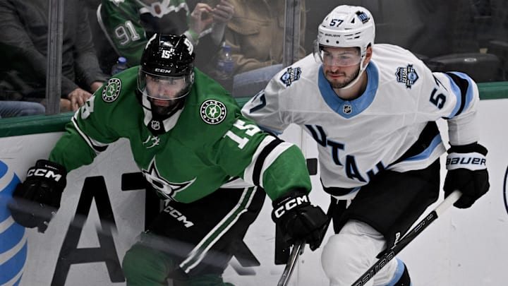 Apr 12, 2025; Dallas, Texas, USA; Dallas Stars center Colin Blackwell (15) and Utah Hockey Club defenseman Nick DeSimone (57) chase the puck lduring the third period at the American Airlines Center. Mandatory Credit: Jerome Miron-Imagn Images