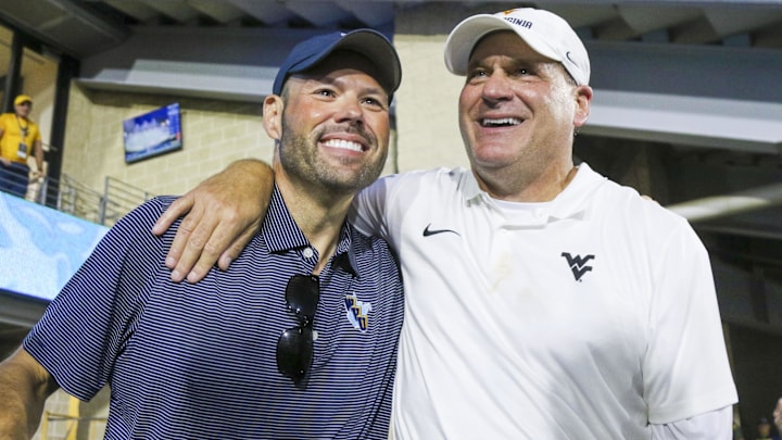 Sep 13, 2025; Morgantown, West Virginia, USA; West Virginia Mountaineers head coach Rich Rodriguez celebrates with West Virginia University athletic director Wren Baker after defeating the Pittsburgh Panthers at Milan Puskar Stadium. Mandatory Credit: Ben Queen-Imagn Images