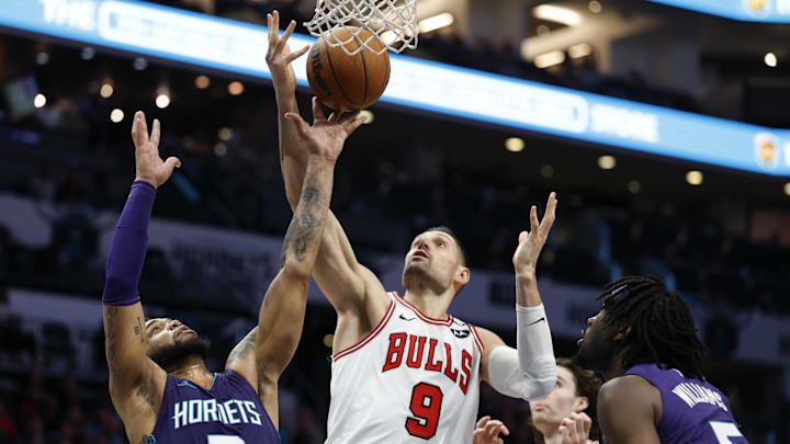 Apr 6, 2025; Charlotte, North Carolina, USA; Chicago Bulls center Nikola Vucevic (9) and Charlotte Hornets forward Miles Bridges (0) fight for a rebound during the second half at Spectrum Center. Mandatory Credit: Nell Redmond-Imagn Images