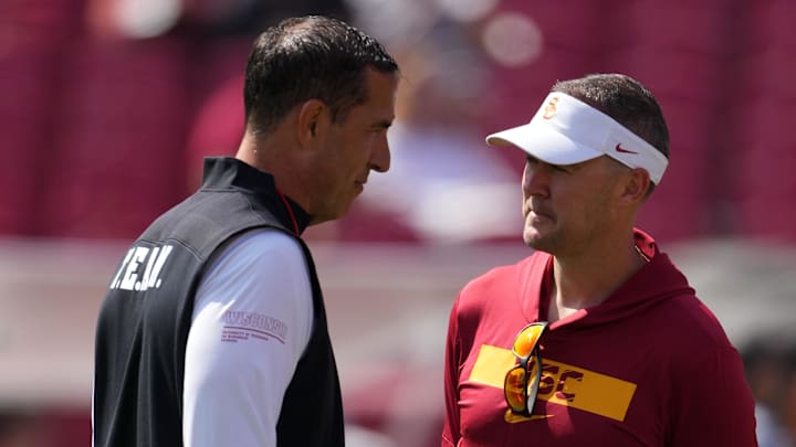 Wisconsin Badgers head coach Luke Fickell (left) talks with Southern California Trojans head coach Lincoln Riley before a game at United Airlines Field at Los Angeles Memorial Coliseum. Wisconsin Badgers head coach Luke Fickell (left) talks with Southern California Trojans head coach Lincoln Riley before a game at United Airlines Field at Los Angeles Memorial Coliseum.