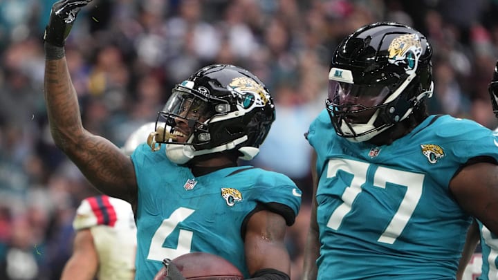 Oct 20, 2024; London, United Kingdom; Jacksonville Jaguars running back Tank Bigsby (4) celebrates with offensive tackle Anton Harrison (77) after scoring on a 1-yard touchdown run against the New England Patriots in the first half of an NFL International Series game at Wembley Stadium. Mandatory Credit: Kirby Lee-Imagn Images