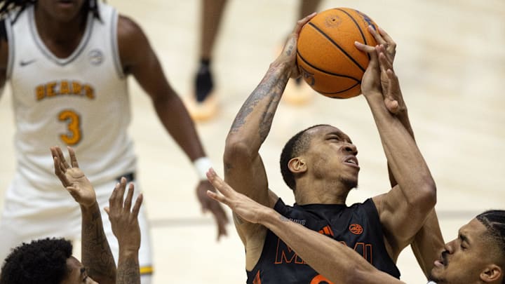 Jan 25, 2025; Berkeley, California, USA; Miami Hurricanes guard Matthew Cleveland (0) shoots the ball against California Golden Bears guard Jovan Blacksher Jr. (10) and guard Christian Tucker (22) during the second half at Haas Pavilion. Mandatory Credit: D. Ross Cameron-Imagn Images