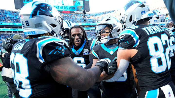 Dec 22, 2024; Charlotte, North Carolina, USA; Carolina Panthers running back Chuba Hubbard (30) celebrates with guard Damien Lewis (68) and cornerback Jaycee Horn (8) and tight end Tommy Tremble (82) after scoring a touchdown to win the game in overtime at Bank of America Stadium.