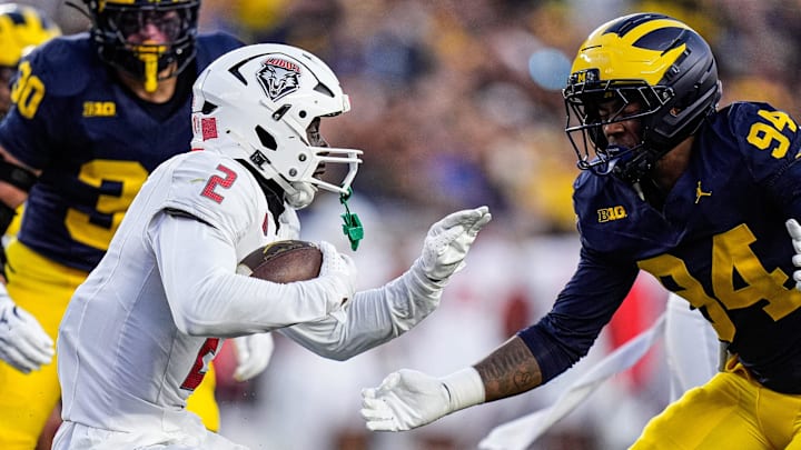 New Mexico quarterback Jack Layne runs against Michigan edge Nate Marshall 