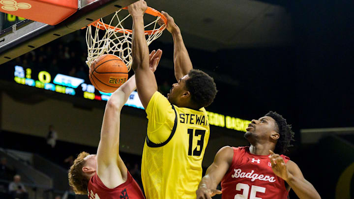 Oregon forward Sean Stewart, center, dunks over coverage from Wisconsin forward Austin Rapp, left, and guard John Blackwell as the Oregon Ducks host the Wisconsin Badgers on Feb. 25, 2026, at Matthew Knight Arena in Eugene, Oregon.