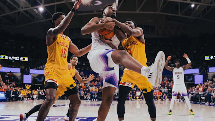 KC Ibekwe of the Huskies beats a pair of Maryland players to this rebound. 