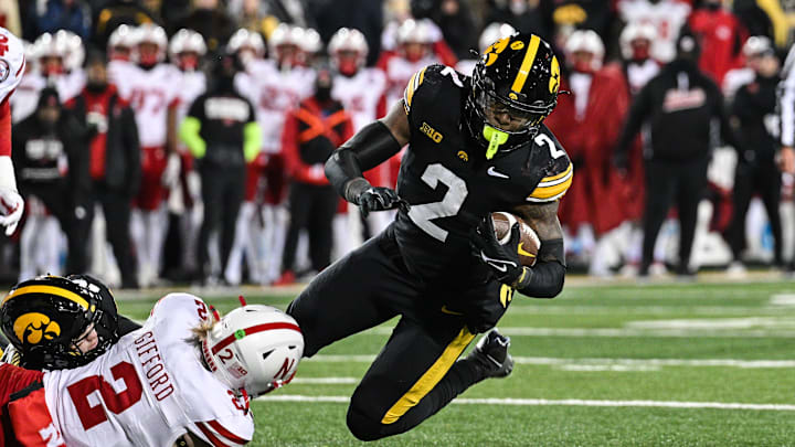 Nov 29, 2024; Iowa City, Iowa, USA; Iowa Hawkeyes running back Kaleb Johnson (2) runs the ball as Nebraska Cornhuskers defensive back Isaac Gifford (2) makes the tackle during the third quarter at Kinnick Stadium. Mandatory Credit: Jeffrey Becker-Imagn Images