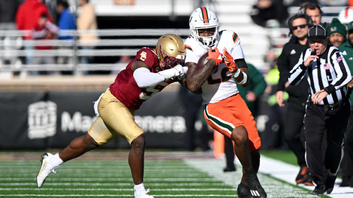 Nov 24, 2023; Chestnut Hill, Massachusetts, USA; Miami Hurricanes running back Mark Fletcher Jr. (22) runs against Boston College Eagles linebacker Kam Arnold (5) during the first half at Alumni Stadium. Mandatory Credit: Brian Fluharty-USA TODAY Sports
