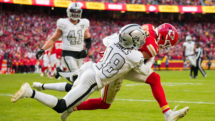 Nov 29, 2024; Kansas City, Missouri, USA; Kansas City Chiefs wide receiver Justin Watson (84) catches a touchdown pass against Las Vegas Raiders cornerback Jack Jones (18) during the first half at GEHA Field at Arrowhead Stadium. Mandatory Credit: Jay Biggerstaff-Imagn Images