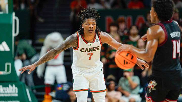 Mar 7, 2026; Coral Gables, Florida, USA; Miami Hurricanes forward Shelton Henderson (7) defends against Louisville Cardinals guard Adrian Wooley (14) during the second half at Watsco Center. Mandatory Credit: Jeff Romance-Imagn Images