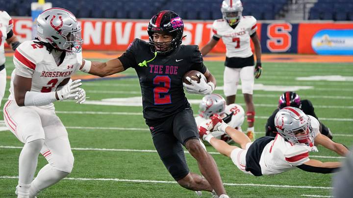 Monroe’s Messiah Hampton races down the sideline to pick up a first down in the first half before being pushed out by Sleepy Hollow’s Brayden Richardson during the NYSPHSAA Class B championship final Saturday, Dec. 6, 2025 at the JMA Wireless Dome in Syracuse.
