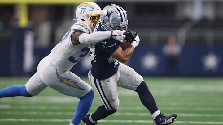 Los Angeles Chargers safety Thomas Harper grabs the face mask of Dallas Cowboys running back Deuce Vaughn.