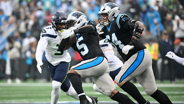 Dec 28, 2025; Charlotte, North Carolina, USA; Carolina Panthers running back Rico Dowdle (5) runs the ball against Seattle Seahawks safety Nick Emmanwori (3) during the first quarter at Bank of America Stadium. Mandatory Credit: Bob Donnan-Imagn Images