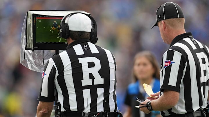 Oct 23, 2021; Pasadena, California, USA; NCAA referee Mark Duddy (R) and  back judge David Ross (B) video review a play in the second half of the game between the UCLA Bruins and the Oregon Ducks  at Rose Bowl. Oregon defeated UCLA 34-31.  Mandatory Credit: Kirby Lee-Imagn Images