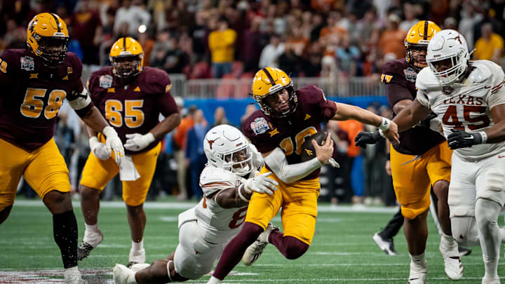 Arizona State Sun Devils quarterback Sam Leavitt (10) evades a tackle from Texas Longhorns linebacker Trey Moore (8) during the first overtime period as the Texas Longhorns play the Arizona State Sun Devils in the Peach Bowl College Football Playoff quarterfinal at Mercedes-Benz Stadium in Atlanta, Georgia, Jan. 1, 2025.
