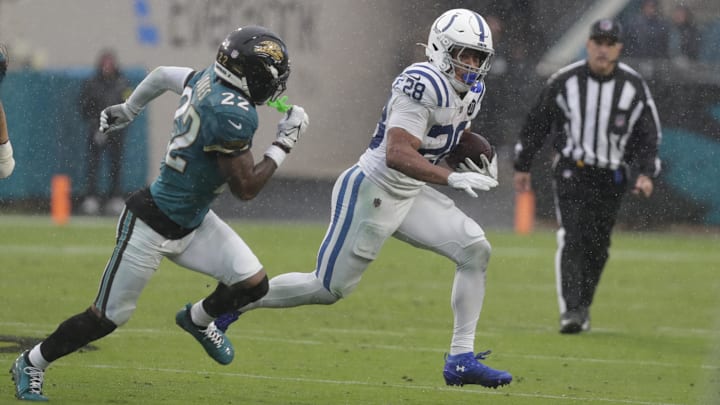 Dec 7, 2025; Jacksonville, Florida, USA; Indianapolis Colts running back Jonathan Taylor (28) carries the ball as Jacksonville Jaguars cornerback Jarrian Jones (22) during the first half at EverBank Stadium. Mandatory Credit: Travis Register-Imagn Images