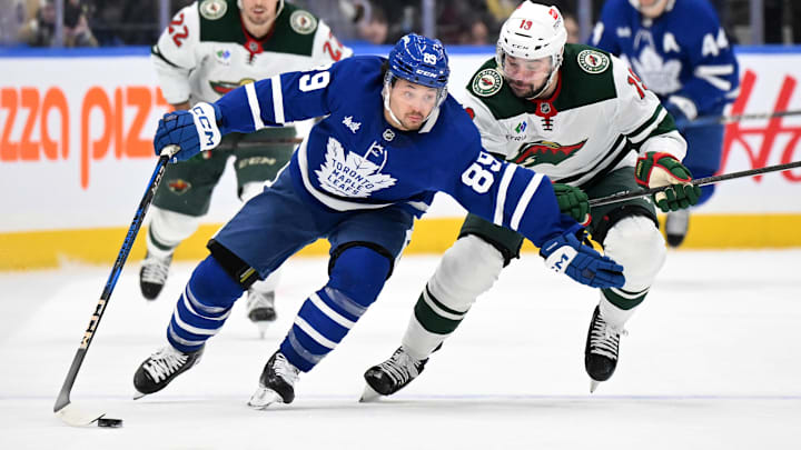 Jan 29, 2025; Toronto, Ontario, CAN;  Toronto Maple Leafs   forward Nick Robertson (89) skates with the puck against Minnesota Wild forward Devin Shore (19) in the first period at Scotiabank Arena. Mandatory Credit: Dan Hamilton-Imagn Images