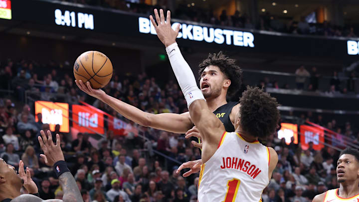 Mar 15, 2024; Salt Lake City, Utah, USA; Utah Jazz guard Johnny Juzang (33) goes to the basket against Atlanta Hawks forward Jalen Johnson (1) during the third quarter at Delta Center. Mandatory Credit: Rob Gray-Imagn Images