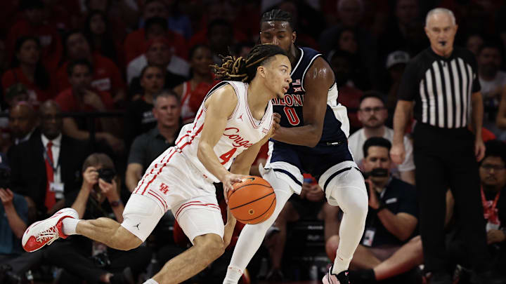 Feb 21, 2026; Houston, Texas, USA;  Houston Cougars guard Kingston Flemings (4) dribbles against Arizona Wildcats guard Jaden Bradley (0) in the first half at Fertitta Center. 