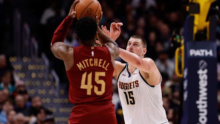 Dec 27, 2024; Denver, Colorado, USA; Cleveland Cavaliers guard Donovan Mitchell (45) attempts a shot as Denver Nuggets center Nikola Jokic (15) defends in the third quarter at Ball Arena. Mandatory Credit: Isaiah J. Downing-Imagn Images