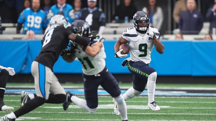 Dec 28, 2025; Charlotte, North Carolina, USA; Seattle Seahawks running back Kenneth Walker III (9) runs the ball against Carolina Panthers cornerback Jaycee Horn (8) during the first quarter at Bank of America Stadium. Mandatory Credit: Jim Dedmon-Imagn Images