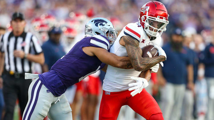 Sep 13, 2024; Manhattan, Kansas, USA; Arizona Wildcats wide receiver Tetairoa McMillan (4) is tackled by Kansas State Wildcats cornerback Keenan Garber (1) during the first quarter at Bill Snyder Family Football Stadium. Mandatory Credit: Scott Sewell-Imagn Images