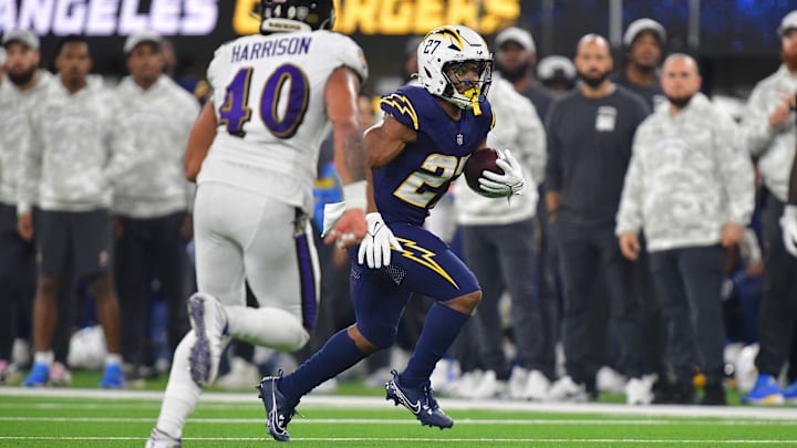 Nov 25, 2024; Inglewood, California, USA; Los Angeles Chargers running back J.K. Dobbins (27) runs the ball against Baltimore Ravens linebacker Malik Harrison (40) during the first half at SoFi Stadium. Mandatory Credit: Gary A. Vasquez-Imagn Images