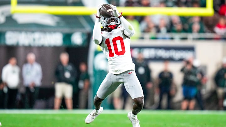 Sep 28, 2024; East Lansing, Michigan, USA; Ohio State Buckeyes cornerback Denzel Burke (10) intercepts a pass against the Michigan State Spartans in the second half at Spartan Stadium on Saturday.