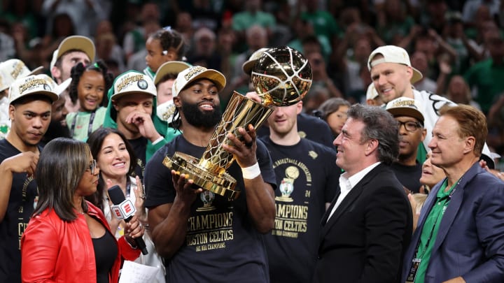 Jun 17, 2024; Boston, Massachusetts, USA; Boston Celtics guard Jaylen Brown (7) holds the trophy after winning the 2024 NBA Finals against the Dallas Mavericks at TD Garden. Mandatory Credit: Peter Casey-USA TODAY Sports