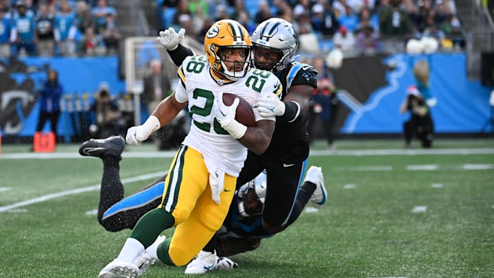 Dec 24, 2023; Charlotte, North Carolina, USA; Green Bay Packers running back AJ Dillon (28) with the ball as Carolina Panthers defensive tackle DeShawn Williams (96) and linebacker Brian Burns (0) defend in the fourth quarter at Bank of America Stadium.