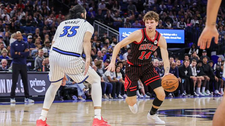 Dec 1, 2025; Orlando, Florida, USA; Chicago Bulls forward Matas Buzelis (14) drives against Orlando Magic center Goga Bitadze (35) during the second half at Kia Center. Mandatory Credit: Mike Watters-Imagn Images