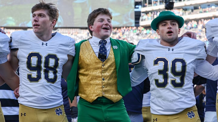 Oct 26, 2024; East Rutherford, New Jersey, USA; Notre Dame Fighting Irish place kicker Mitch Jeter (98) and long snapper Rino Monteforte (39) sing the Notre Dame alma mater with the leprechaun after the game against the Navy Midshipmen at MetLife Stadium. Mandatory Credit: Vincent Carchietta-Imagn Images