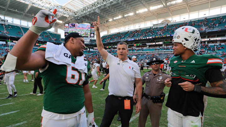 Nov 23, 2024; Miami Gardens, Florida, USA; Miami Hurricanes head coach Mario Cristobal celebrates with Miami Hurricanes offensive lineman Francis Mauigoa (61) and tight end Elijah Arroyo (8) after the game against the Wake Forest Demon Deacons at Hard Rock Stadium. Mandatory Credit: Sam Navarro-Imagn Images