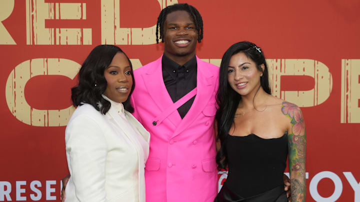 Travis Hunter with his mother Ferrante Harris and his fiancee Leanna Lenee on the red carpet before the 2025 NFL Draft at Lambeau Field.