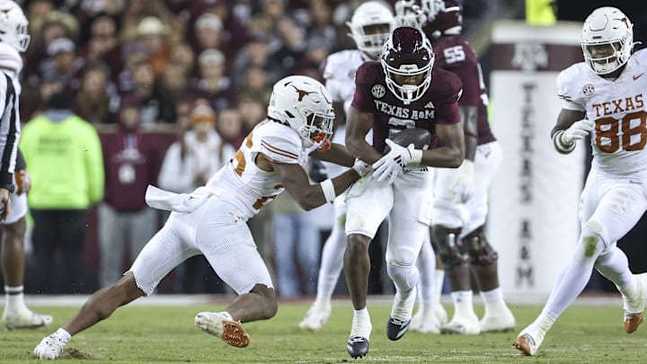 Nov 30, 2024; College Station, Texas, USA; Texas A&M Aggies wide receiver Terry Bussey (2) runs with the ball as Texas Longhorns linebacker Ty'Anthony Smith (26) attempts to make a tackle during the fourth quarter at Kyle Field. Mandatory Credit: Troy Taormina-Imagn Images Nov 30, 2024; College Station, Texas, USA; Texas A&M Aggies wide receiver Terry Bussey (2) runs with the ball as Texas Longhorns linebacker Ty'Anthony Smith (26) attempts to make a tackle during the fourth quarter at Kyle Field. Mandatory Credit: Troy Taormina-Imagn Images