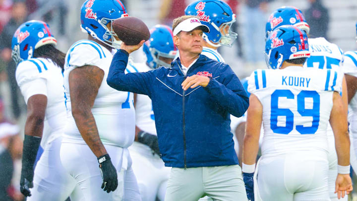 Oct 25, 2025; Norman, Oklahoma, USA;  Ole Miss Rebels head coach Lane Kiffin throws a football before the game against the Oklahoma Sooners at Gaylord Family-Oklahoma Memorial Stadium. Mandatory Credit: Kevin Jairaj-Imagn Images