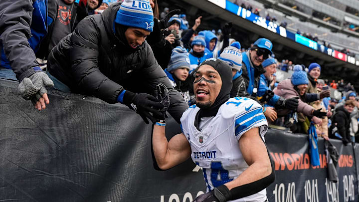 Detroit Lions wide receiver Amon-Ra St. Brown (14) high-fives fans celebrates 34-17 win over Chicago Bears as he exits the field at Soldier Field in Chicago, Ill. on Sunday, Dec. 22, 2024. Detroit Lions wide receiver Amon-Ra St. Brown (14) high-fives fans celebrates 34-17 win over Chicago Bears as he exits the field at Soldier Field in Chicago, Ill. on Sunday, Dec. 22, 2024.