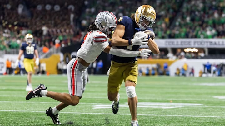 Jan 20, 2025; Atlanta, GA, USA; Notre Dame Fighting Irish wide receiver Jaden Greathouse (1) makes a catch for a touchdown against Ohio State Buckeyes cornerback Jordan Hancock (7) during the second half the CFP National Championship college football game at Mercedes-Benz Stadium. Mandatory Credit: Mark J. Rebilas-Imagn Images Jan 20, 2025; Atlanta, GA, USA; Notre Dame Fighting Irish wide receiver Jaden Greathouse (1) makes a catch for a touchdown against Ohio State Buckeyes cornerback Jordan Hancock (7) during the second half the CFP National Championship college football game at Mercedes-Benz Stadium. Mandatory Credit: Mark J. Rebilas-Imagn Images