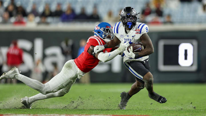 Jan 2, 2025; Jacksonville, FL, USA; Duke Blue Devils running back Jaquez Moore (9) is chased by Mississippi Rebels linebacker Suntarine Perkins (4) in the second quarter during the Gator Bowl at EverBank Stadium. Mandatory Credit: Nathan Ray Seebeck-Imagn Images