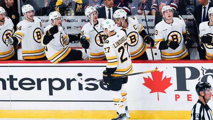 Oct 2, 2026; Winnipeg, Manitoba, CAN; Boston Bruins defenseman Hampus Lindholm (27) is congratulated by his team mates on his goal against the Winnipeg Jets during the first period at Canada Life Centre. Mandatory Credit: Terrence Lee-Imagn Images Oct 2, 2026; Winnipeg, Manitoba, CAN; Boston Bruins defenseman Hampus Lindholm (27) is congratulated by his team mates on his goal against the Winnipeg Jets during the first period at Canada Life Centre. Mandatory Credit: Terrence Lee-Imagn Images