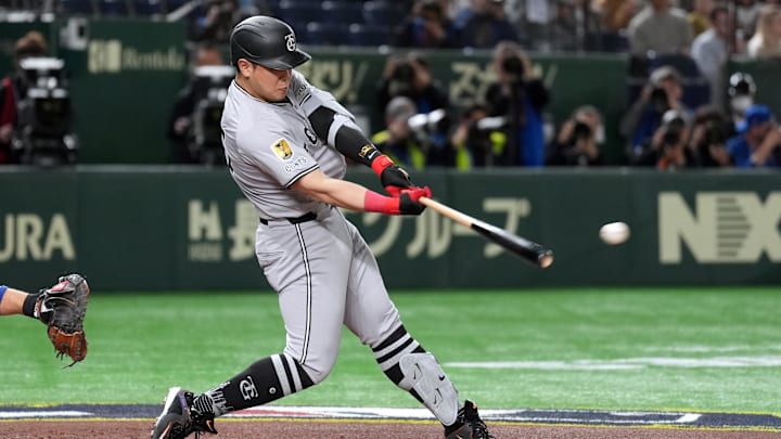 Mar 16, 2025; Bunkyo, Tokyo, Japan; Yomiuri Giants first baseman Kazuma Okamoto (25) hits a single against the Chicago Cubs during the second inning at Tokyo Dome. Mandatory Credit: Darren Yamashita-Imagn Images