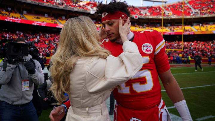 Kansas City Chiefs quarterback Patrick Mahomes (15) kisses his wife Brittany Mahomes before a 2025 AFC divisional round game against the Houston Texans at GEHA Field at Arrowhead Stadium.