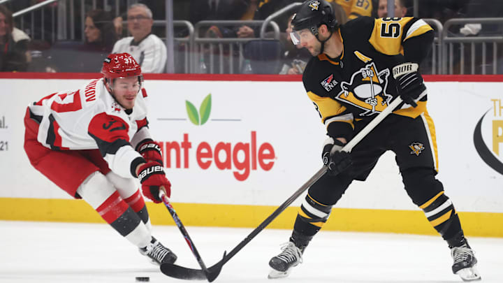 Dec 30, 2025; Pittsburgh, Pennsylvania, USA; Pittsburgh Penguins defenseman Kris Letang (58) passes the puck against Carolina Hurricanes right wing Andrei Svechnikov (37) during the second period at PPG Paints Arena. Mandatory Credit: Charles LeClaire-Imagn Images