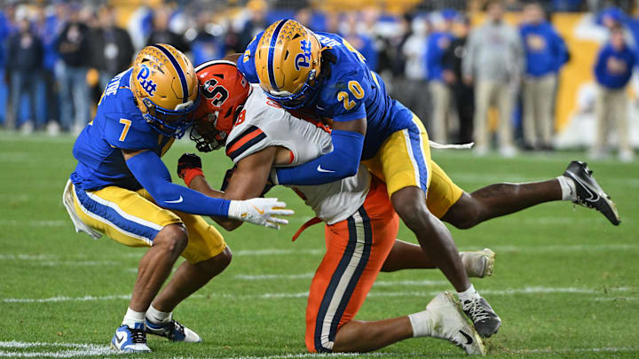 Oct 24, 2024; Pittsburgh, Pennsylvania, USA; Pittsburgh Panthers linebacker Jordan Bass (20) and defensive back Javon McIntyre (7) tackle Syracuse Orange wide receiver Emanuel Ross (18) during the second quarter at Acrisure Stadium. Mandatory Credit: Barry Reeger-Imagn Images