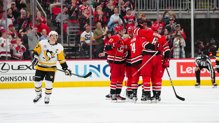 Nov 7, 2024; Raleigh, North Carolina, USA;  Carolina Hurricanes defenseman Jaccob Slavin (74) is congratulated by defenseman Brent Burns (8) and  right wing Andrei Svechnikov (37) after his goal against the Pittsburgh Penguins during the second period at Lenovo Center. Mandatory Credit: James Guillory-Imagn Images