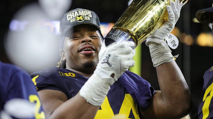 Michigan defensive lineman Kris Jenkins (94) picks up the trophy to celebrate the Wolverines' 34-13