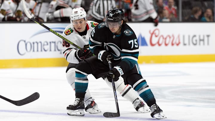 Oct 31, 2024; San Jose, California, USA; Chicago Blackhawks center Connor Bedard (98) and San Jose Sharks left winger Daniel Gushchin (75) battle for the puck during the first period at SAP Center at San Jose. Mandatory Credit: D. Ross Cameron-Imagn Images