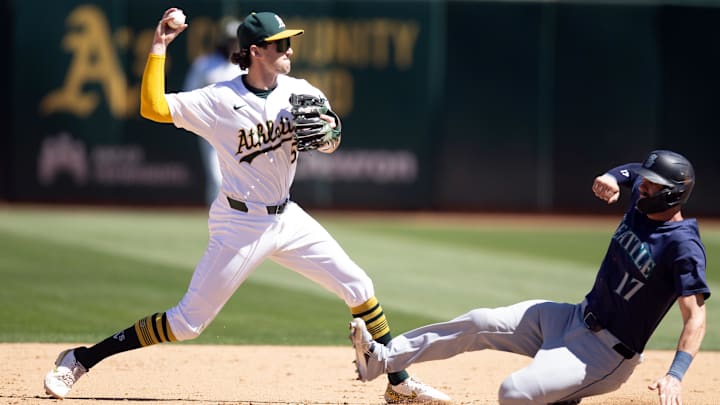 Sep 5, 2024; Oakland, California, USA; Oakland Athletics shortstop Jacob Wilson (5) throws over Seattle Mariners right fielder Mitch Haniger (17) too late to complete a double play during the sixth inning at Oakland-Alameda County Coliseum. Leo Rivas was safe at first base. Mandatory Credit: D. Ross Cameron-Imagn Images